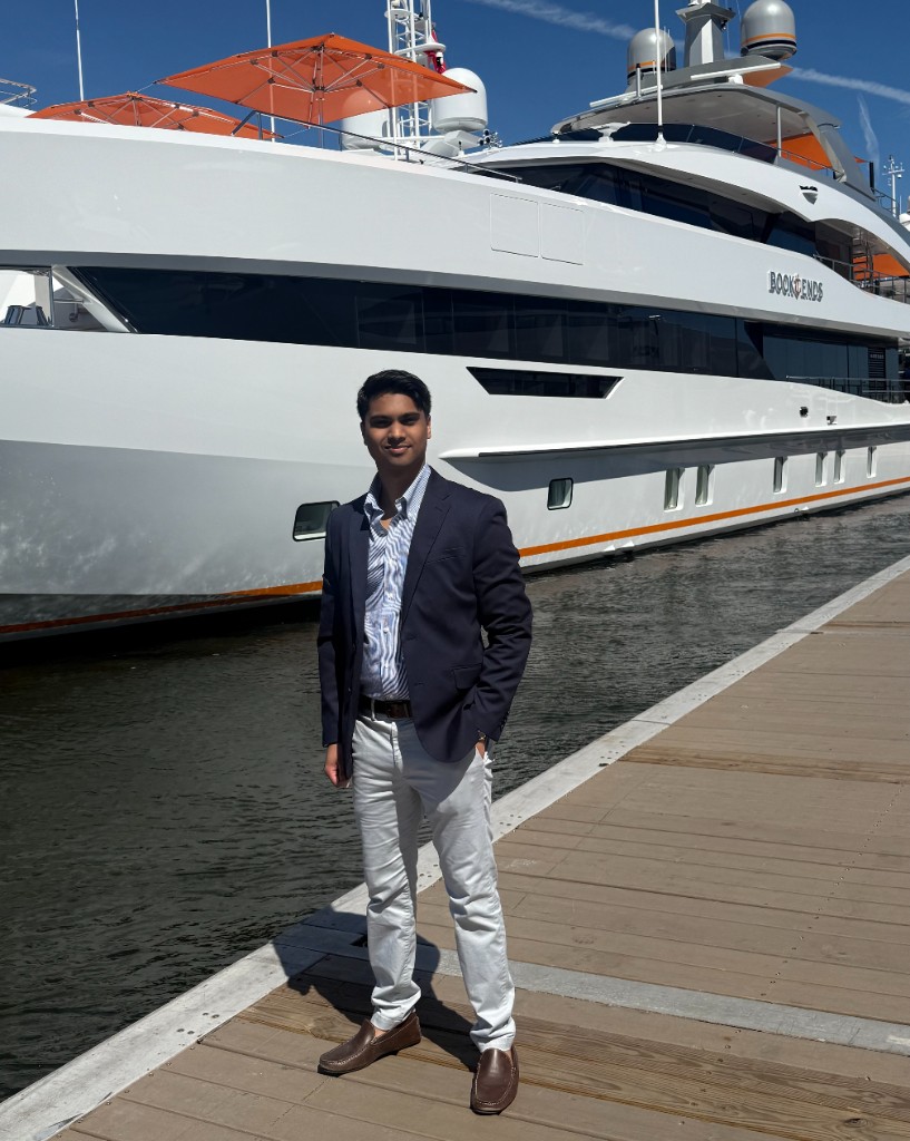 Justin Boodram standing beside the yacht Bookends.